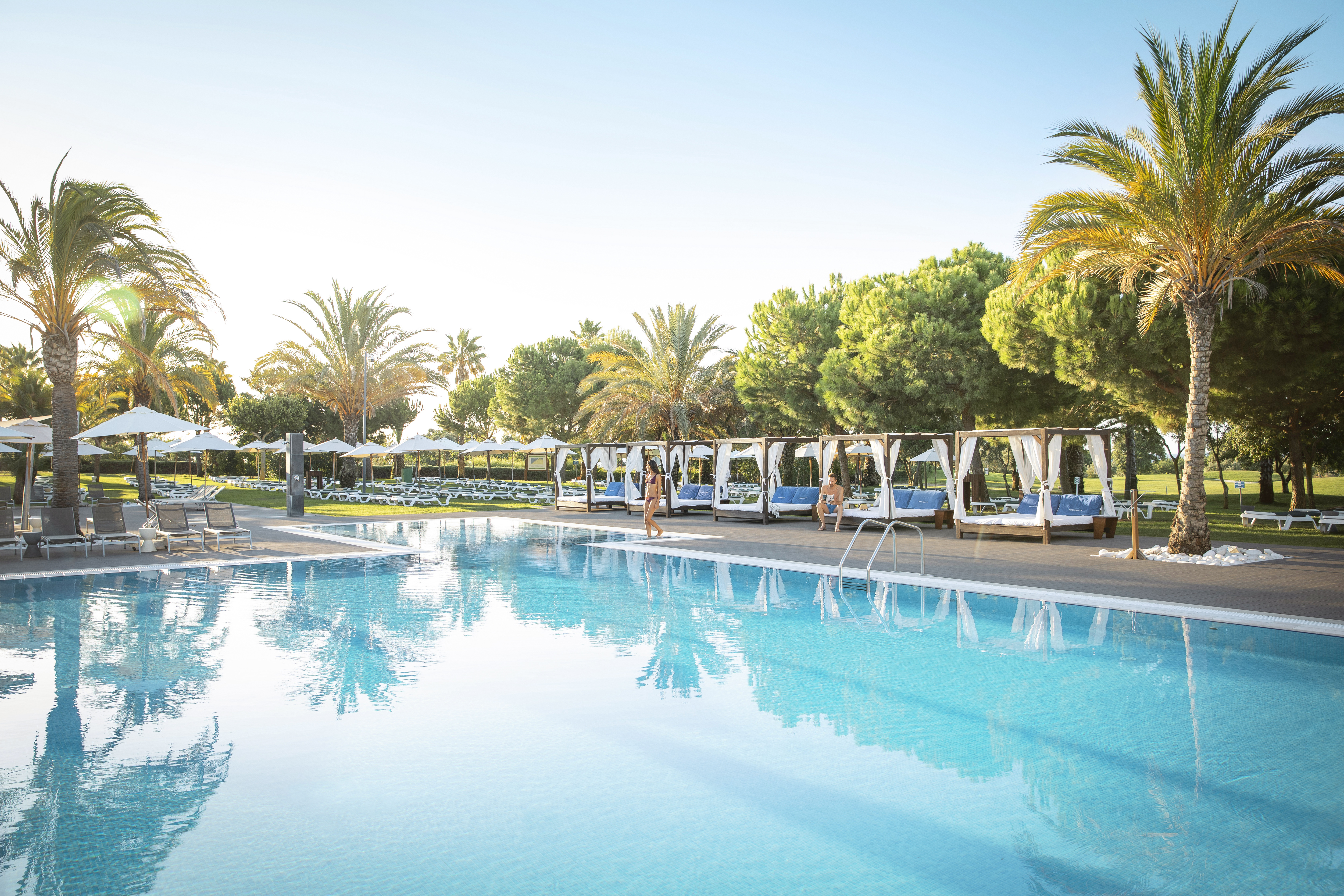 Front of zip tote bag with white canvas, black canvas straps and handle, and black zipper pulls.